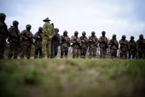 A member of the Australian Armed Forces speaks to Ukrainian soldiers in Wiltshire, England.